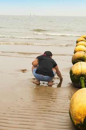 sea tide has left the buoys on the sand beach which plays a girlの写真素材