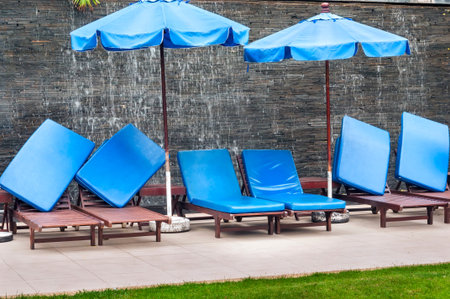 Several of beach loungers with mattresses on the background of a waterfallの写真素材