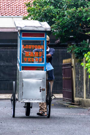 man street food seller pushing the blue cart on the residential streetのeditorial素材