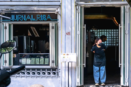 Female waitress waiting for the next costumer on the front door of the coffee shop