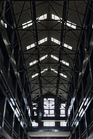 Industrial interior of an old factory building with a large steel roof