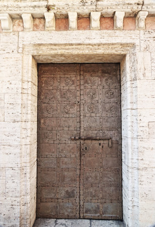 Old wooden door in the medieval city of Assisi, Umbria region, central Italyの写真素材