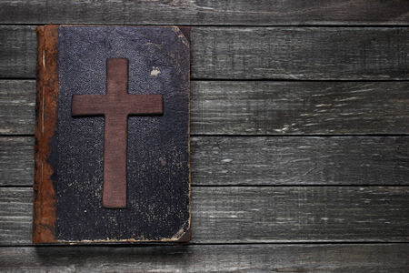 Old book and cross on wooden table の写真素材