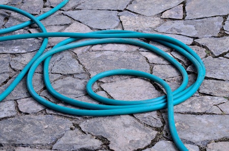 Green rubber tube for watering plants paced the rolls on a corridor made   of stone at Mae Fah Luang Arboretum Chiang Rai province northern of Thailand の写真素材