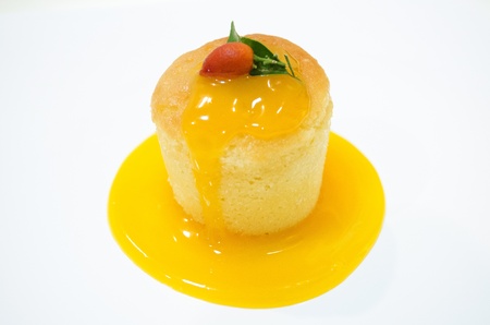 The yellow cupcake with passion fruit sauce on white background の写真素材