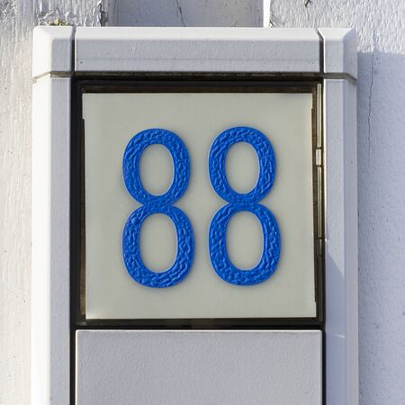 wrinkled plastic house number 88, blue font type on white backgroundの写真素材