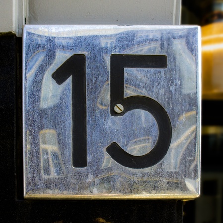 glossy house number fifteen, with the reflection of the houses oppositeの写真素材