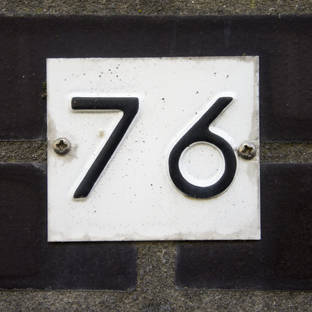 house number seventy-six embossed in a metal plate