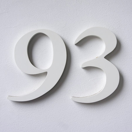 three dimensional house number ninety three white lettering on a white wall