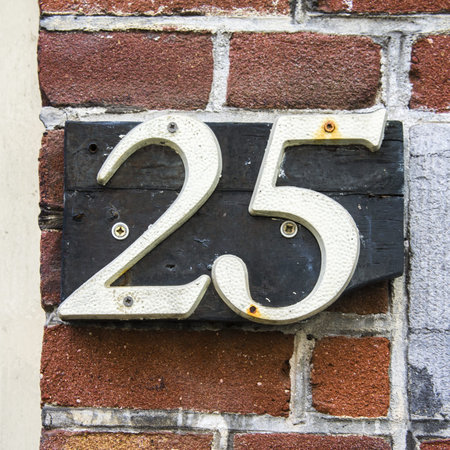 housenumber twenty five, seperate white numbers attached to a broken wooden plank.