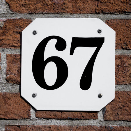 new house number sixty seven, black lettering on a white plate