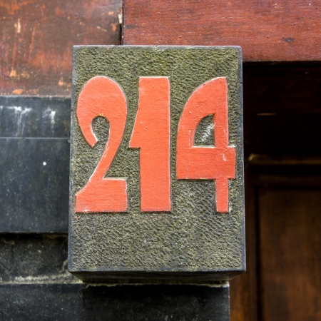 house number two hundred and fourteen cut out in natural stone, painted red の写真素材