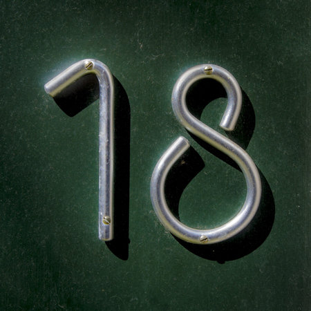 house number eightteen made out of a bent aluminum bar
