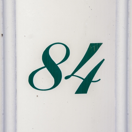 green house number eighty-four, painted on a white doorpost.の写真素材