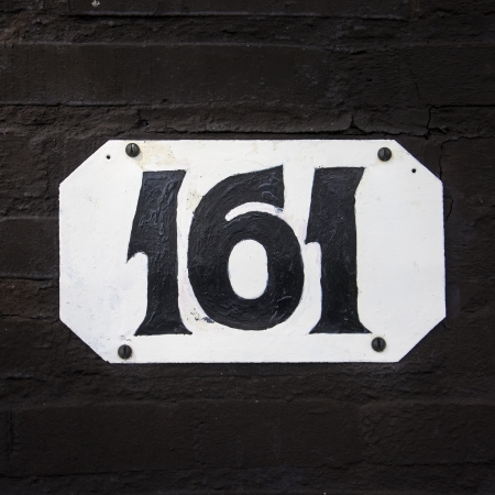 House number one hundred and sixty-one  Hand painted on a white plate の写真素材