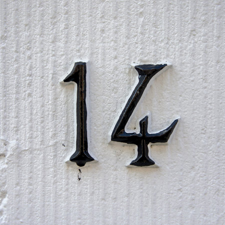 House number fourteen on a white wall.