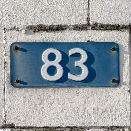 house number eighty-three  White font embossed in a blu plate