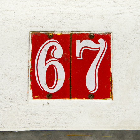 house number sixty seven on two enameled plates. white lettering on a red backgroundの写真素材