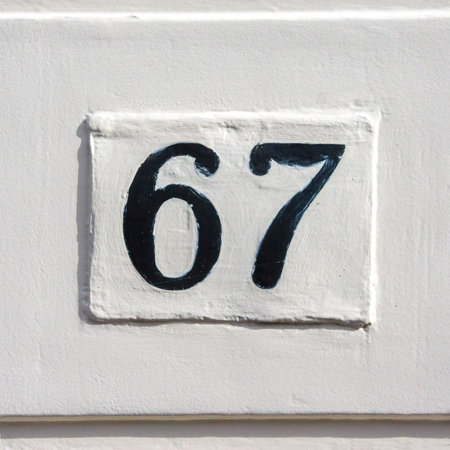 house number sixty seven. Black numerals on a white plate