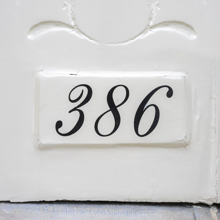 house number three hundred and eighty six. Black numerals on a white backgroundの写真素材