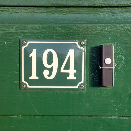enameled house number one hundred and ninety four, next to a doorbell