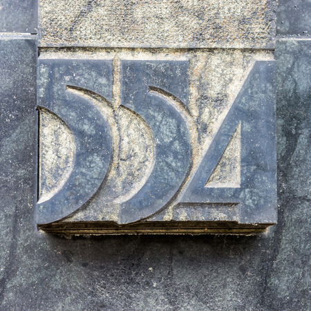 house number five hundred and fifty four, carved in natural stoneの写真素材