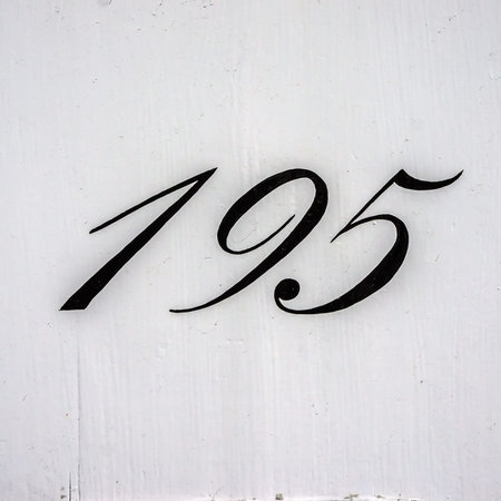House number one hundred and ninety five, hand painted on a lacquered panel. 195