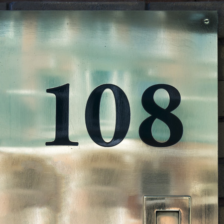 House number one hundred and eight engraved in an reflective metal plate.の写真素材
