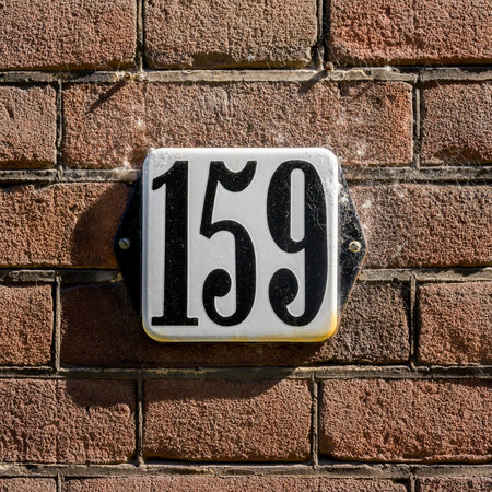 Enameled house number one hundred and fifty nine. Black numerals on a white background.
