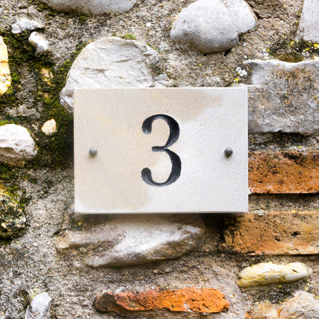 house number three engraved in natural stone