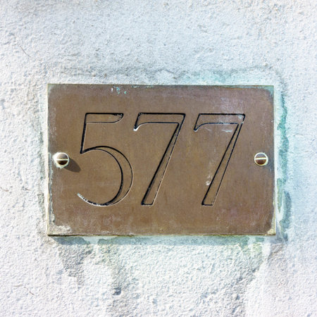house number five hundred and seventy seven engraved in a brass plateの写真素材