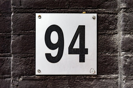 Modern house number ninety four (94) engraved in a plate