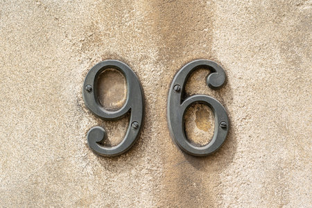 Bronze house number ninety six on an old stone wallの写真素材