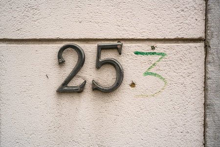 incomplete metal house number two hundred and fifty three. With the three written next to itの写真素材