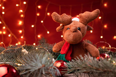 Portrait of a cute reindeer toy in santa hat sitting in a Christmasの写真素材
