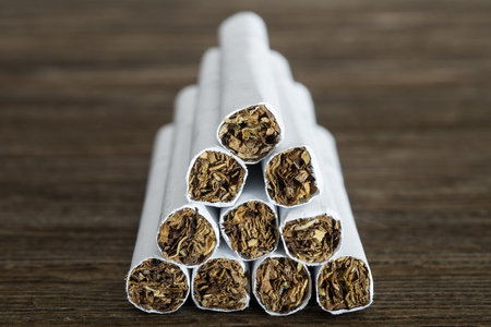 Pyramid of cigarettes on old wood table.