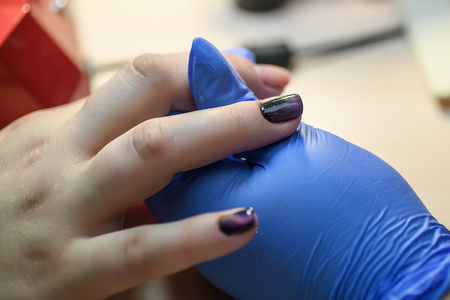 Manicure. Master does manicure on nails paint hand.の写真素材