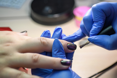 Manicure. Master does manicure on nails paint hand.の写真素材