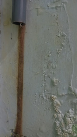 Detail of an old wall with rust and peeling paint.の写真素材