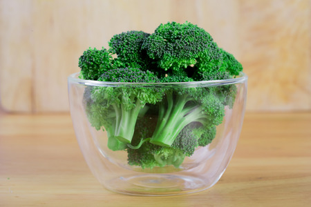 Fresh salad with mixed greens  in bowl on wooden backgroundの写真素材