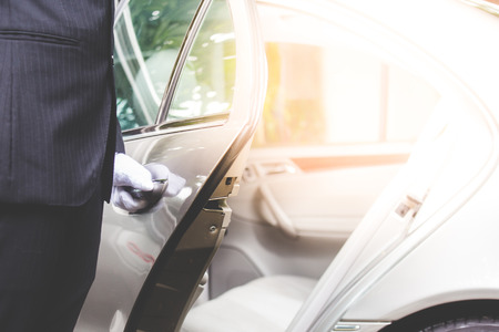 Closeup of Chauffeur opening car door with gloveの写真素材