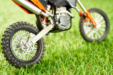 closeup of artificial green grass with motorcycle model