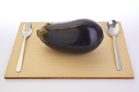 Cutting eggplants on wooden cutting board before cookingの写真素材