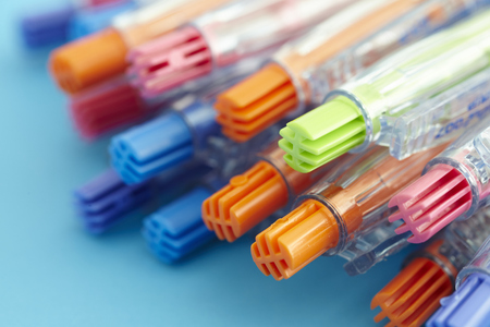 shooting different kinds of pens isolated on blue backgroundの写真素材