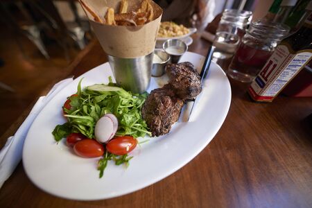 Grilled beef steaks and vegetables on the wood tableの写真素材
