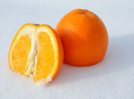 Close-up of pieces of cut orange in white snow の写真素材