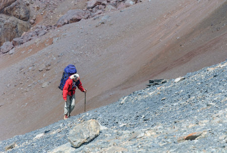 Lonely man climbing on the top with backpackon Pamir Mountainの写真素材