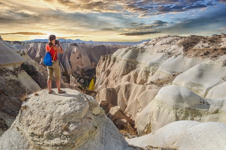 Young woman take photo majestic sunset in Cappadocia. Red Valleyの写真素材