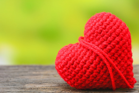 Red heart on wooden table with nature backgroundの写真素材