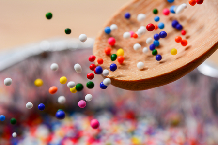 Sugar sprinkle dots drop from spoon, decoration for cake and bakeryの写真素材